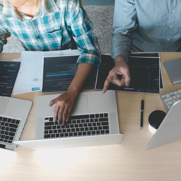 Two people working on computers doing website coding